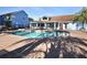 Outdoor pool and pool house featuring lounge chairs, tables, and chairs for seating at 2739 N Poinciana Blvd # 77, Kissimmee, FL 34746