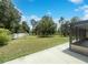 Backyard featuring a large grassy area, mature trees, and a screened patio area at 281 Covent Gardens Pl, Deltona, FL 32725