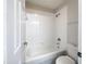 Bright bathroom featuring a bathtub with white tile surround, a shower head, and a toilet at 281 Covent Gardens Pl, Deltona, FL 32725