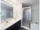 Bathroom with double sinks, large mirror, and combination shower and soaking tub at 281 Covent Gardens Pl, Deltona, FL 32725
