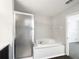 Bathroom featuring a tub with sliding shower doors next to a large soaking tub at 281 Covent Gardens Pl, Deltona, FL 32725