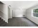 Open living room area featuring updated carpet, a window, and a staircase at 281 Covent Gardens Pl, Deltona, FL 32725