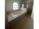 Bright bathroom features soaking tub beneath arched window and glass-enclosed shower at 402 Big Sioux Ct, Kissimmee, FL 34759