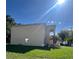 Side view of the two-story home and side yard with green grass at 402 Big Sioux Ct, Kissimmee, FL 34759