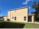 Rear view of the two-story home with grassy backyard and AC unit at 402 Big Sioux Ct, Kissimmee, FL 34759