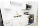 Modern kitchen featuring white cabinetry, gold hardware, stainless steel appliances, and a tile backsplash at 4469 Evers Pl, Orlando, FL 32811