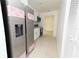 Open kitchen layout showcases stainless steel refrigerator and modern appliances with tile flooring at 4469 Evers Pl, Orlando, FL 32811