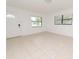 Bright living room with tiled floors, a decorative front door, and natural light from two windows at 4469 Evers Pl, Orlando, FL 32811