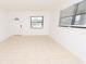 Bright living room with tiled floors, a decorative front door, and natural light from two windows at 4469 Evers Pl, Orlando, FL 32811