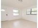 Bright, tiled living space with an exterior door and two windows, perfect for entertaining or relaxation at 4469 Evers Pl, Orlando, FL 32811