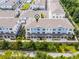 Aerial view of blue and white townhomes with gray roof, green trees, and walking path at 461 Diamond Dove Cv, Winter Springs, FL 32708