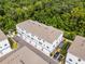 Overhead view of new townhomes with landscaping, rooftop details, and forest background at 461 Diamond Dove Cv, Winter Springs, FL 32708