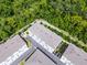 An aerial view of a townhome community featuring landscaping and paved streets surrounded by forest at 461 Diamond Dove Cv, Winter Springs, FL 32708