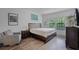 Bedroom with wood floor, two windows, and artwork; furnished with a wooden bed, side table and chair at 461 Diamond Dove Cv, Winter Springs, FL 32708