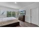 Bright bedroom featuring a TV, dresser and two windows with wood-look floors at 461 Diamond Dove Cv, Winter Springs, FL 32708
