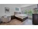 Bedroom with wood floor, two windows, and artwork; furnished with a wooden bed, side table and chair at 461 Diamond Dove Cv, Winter Springs, FL 32708