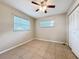Bedroom with neutral walls, ceiling fan, two windows, and tile flooring at 4757 Goldsboro Ct, Orlando, FL 32811