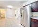 Bright kitchen features stainless steel refrigerator, granite counters, and tile flooring at 4757 Goldsboro Ct, Orlando, FL 32811