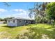 Backyard featuring a well-maintained lawn, playset, and shaded area at 500 E Gottsche Ave, Eustis, FL 32726