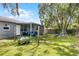 Spacious backyard with lush green lawn, covered patio, and mature trees at 500 E Gottsche Ave, Eustis, FL 32726