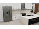 Modern kitchen with white cabinetry, marble countertops, stainless steel appliances, and island with seating at 5025 Sw 179Th Pl, Ocala, FL 34473