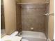 Bathroom features a bathtub with tiled wall and a shower head and a toilet on the side at 5377 Via Appia Way, Sanford, FL 32771