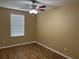 Cozy bedroom with wood-look flooring, a ceiling fan, and a window with blinds providing natural light at 5377 Via Appia Way, Sanford, FL 32771