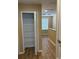 Hallway with wood-look floors leading to a linen closet and a window providing natural light at 5377 Via Appia Way, Sanford, FL 32771