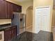 A kitchen showcasing dark cabinets, stainless steel appliances, and granite countertops at 5377 Via Appia Way, Sanford, FL 32771
