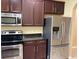 Kitchen with granite countertops, stainless steel appliances, and dark wood cabinets at 5377 Via Appia Way, Sanford, FL 32771