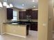 Modern kitchen with dark wood cabinets, stainless steel appliances, and a breakfast bar at 5377 Via Appia Way, Sanford, FL 32771