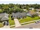 Aerial view of a gray home, dark roof, green lawn and mature landscaping at 645 Macglenross Dr, Oviedo, FL 32765