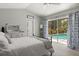 Bedroom with sliding glass door leading to the screened in pool and lanai at 645 Macglenross Dr, Oviedo, FL 32765