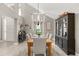 Open concept dining area with a stylish table set, modern chandelier, and a dark wood display cabinet, ideal for entertaining guests at 645 Macglenross Dr, Oviedo, FL 32765