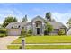 Charming gray home boasts a manicured lawn, arched entry, and attached two-car garage, perfect for Gathering living at 645 Macglenross Dr, Oviedo, FL 32765