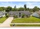 Well-maintained gray home with green lawn, mature landscaping, and a gray roof at 645 Macglenross Dr, Oviedo, FL 32765