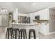 Open kitchen featuring white cabinets and a bar area, seamlessly connected to the rest of the home at 645 Macglenross Dr, Oviedo, FL 32765