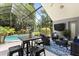 Inviting screened-in lanai with comfortable seating, outdoor dining area, and views of the pool and basketball court at 645 Macglenross Dr, Oviedo, FL 32765