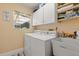 Functional laundry area featuring a washer, dryer, sink, cabinets, and bright window at 645 Macglenross Dr, Oviedo, FL 32765