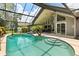 Screened in pool with bright turquoise water and steps leading into the water at 645 Macglenross Dr, Oviedo, FL 32765