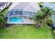 Aerial view of a screened-in pool and backyard with lush landscaping, showcasing an inviting outdoor living space at 697 Broadoak Loop, Sanford, FL 32771