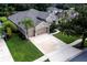 Aerial perspective of a house featuring a spacious driveway, a two-car garage, and green landscaping at 697 Broadoak Loop, Sanford, FL 32771