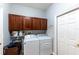 Functional laundry room with overhead cabinets and modern washer/dryer units, offering convenience and storage at 697 Broadoak Loop, Sanford, FL 32771