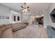 Open-concept living space with a tan sectional sofa, ceiling fan, and adjacent kitchen at 697 Broadoak Loop, Sanford, FL 32771