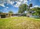 Wide shot of backyard showing the house, a shed, an above-ground pool, a picnic table and fire pit at 706 Lynn Ave, New Smyrna Beach, FL 32168