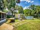 Landscaped backyard featuring green grass, a fire pit, a picnic table, and an above-ground pool and a shed at 706 Lynn Ave, New Smyrna Beach, FL 32168