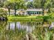 Waterfront backyard with lush foliage featuring a green yard and a screened-in porch on the home at 706 Lynn Ave, New Smyrna Beach, FL 32168