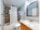 Traditional bathroom featuring a tub with shower, ceramic tiled walls, vanity, and toilet, creating a clean and functional space at 706 Lynn Ave, New Smyrna Beach, FL 32168