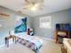 Bedroom featuring colorful quilt, TV, ceiling fan and charming decor, creating a cozy and inviting atmosphere at 706 Lynn Ave, New Smyrna Beach, FL 32168