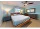 Comfortable bedroom featuring a bed, dresser, ceiling fan and complementing side tables with lamps for a cozy interior at 706 Lynn Ave, New Smyrna Beach, FL 32168